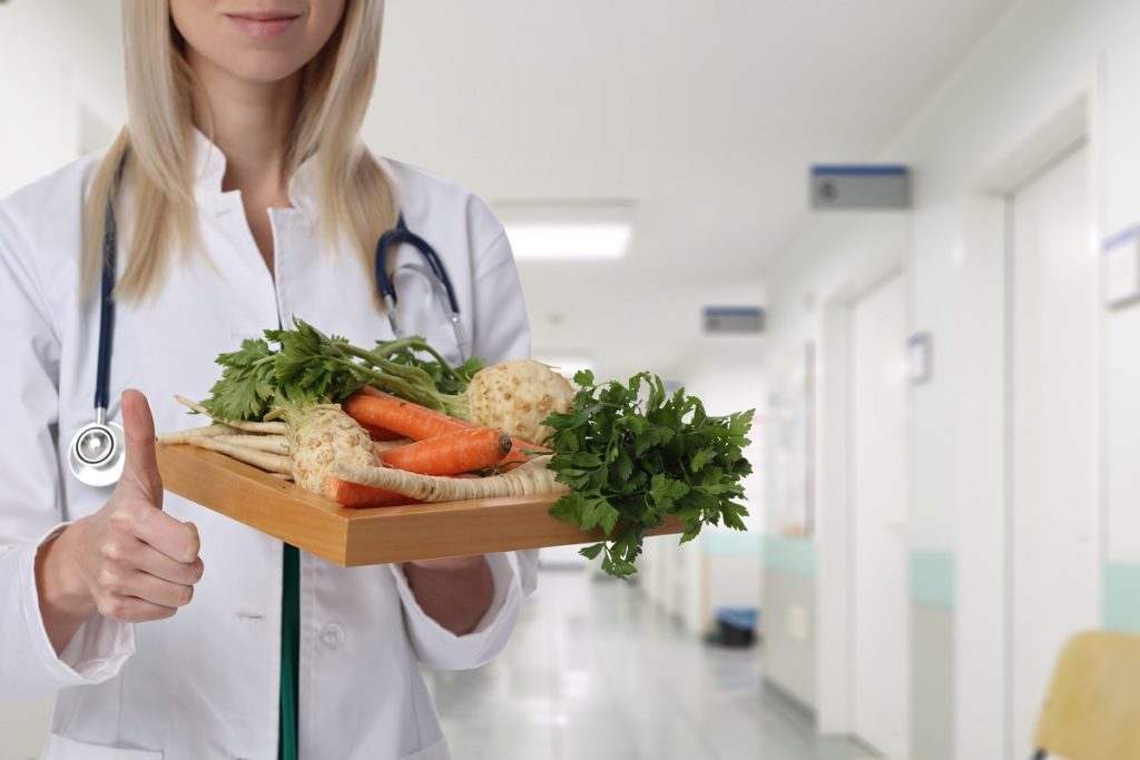 doctor holding plate full of vegetables