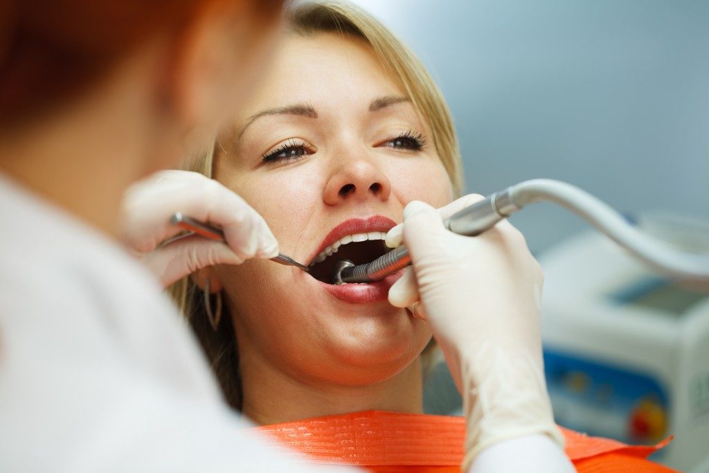 Female having her teeth examined by a dentist