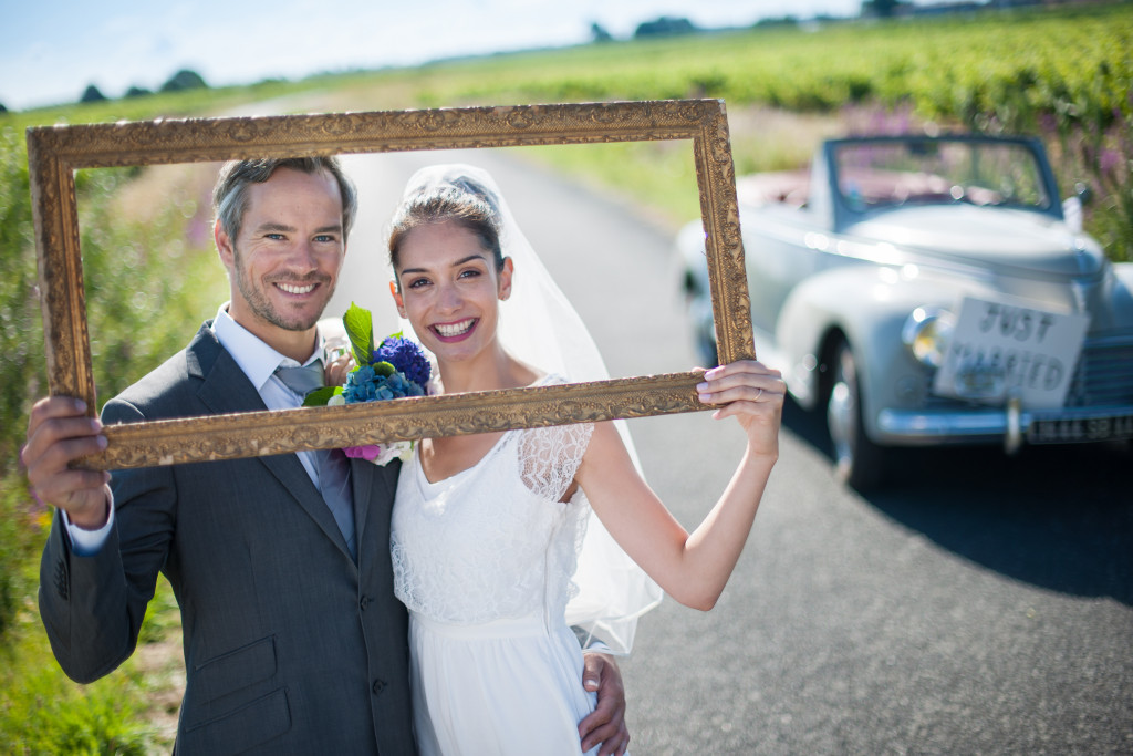 newly wed couple holding up a frame