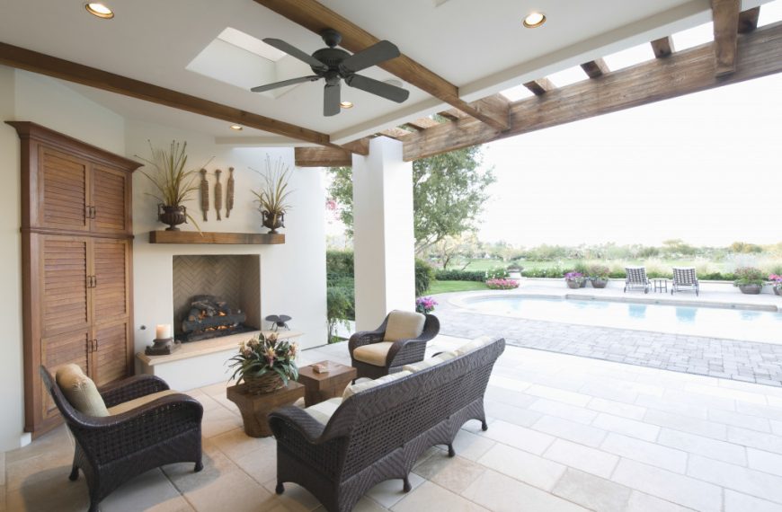 outdoor seating area with fireplace and swimming pool in the distance
